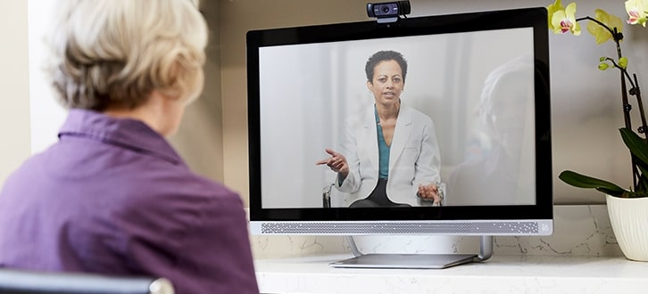 a woman watching her prescriber speak on video