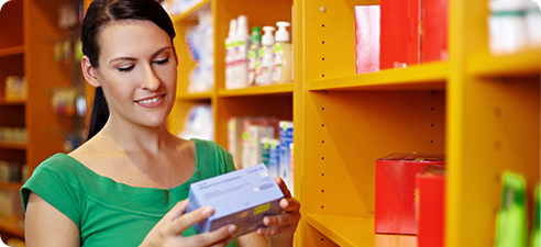 woman checking prescription label on medicine container